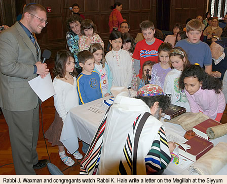 Rabbi Joshua Waxman and congregants watch Rabbi Kevin Hale write a letter on the Megillah at the Siyyum